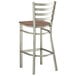 A Lancaster Table & Seating metal ladder back bar stool with a vintage wood seat.