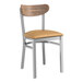 A Lancaster Table & Seating Boomerang Series wooden chair with a tan seat and clear coat finish on the wood and metal.