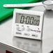 A white AvaTime digital kitchen timer on a metal surface.