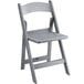 A Lancaster Table & Seating gray resin folding chair with a slatted seat.