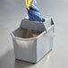 A Rubbermaid gray pail with a blue mop strainer in it.