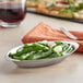 A plate of green beans in a Vollrath stainless steel oval au gratin dish.
