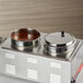 A stainless steel Vigor steam table adapter with 2 bowls of sauce on top.