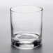 An Arcoroc ArcoPrime Rocks glass with a small amount of liquid and a curved rim.