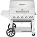 A silver Crown Verity portable outdoor barbecue grill with stainless steel top and wheels.