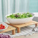 A Tablecraft Sierra white melamine serving bowl filled with salad on a table.