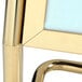 A close up of a brass Aarco double pedestal poster stand.