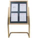 A white menu board with a brass double pedestal frame holding four different menus.
