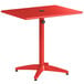 A red Lancaster Table & Seating outdoor table with a black umbrella on it.