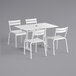 A white Lancaster Table & Seating outdoor table and four chairs.