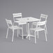 A white Lancaster Table & Seating dining height table with an umbrella hole and 4 white chairs.