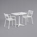 A white Lancaster Table & Seating dining table with two arm chairs.