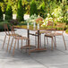 A Lancaster Table & Seating outdoor table with chairs on a patio.