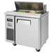 A stainless steel Turbo Air refrigerated sandwich prep table with a salad bar on the counter.