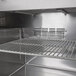 A Turbo Air refrigerated sandwich prep table with a metal rack inside.