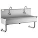 A stainless steel Regency utility sink with two hands-free faucets.