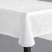A white Choice vinyl table cover on a black table.