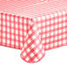 A red and white checkered Choice vinyl table cover on a table with an umbrella opening.