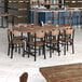 A Lancaster Table & Seating wood table with chairs in a restaurant dining area.