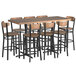A Lancaster Table & Seating bar height table with wooden top and 8 chairs with wooden seats.
