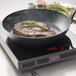 A Spring USA LoPRO Slim-line induction range cooking a steak in a pan with rosemary sprigs.