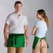 A man and woman wearing Choice Kelly Green waist aprons with black webbing.
