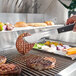 A person cutting meat on a Crown Verity built-in horizontal access door counter next to a grill.
