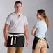 A man and woman wearing black Choice waist aprons with natural webbing over white shirts.