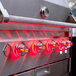 A close up of a Crown Verity built-in grill with red lights.