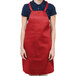 A woman wearing a red Chef Revival bib apron.
