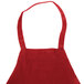 A red Chef Revival apron with a pocket on a counter.