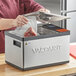 A person using a VacPak-It Sous Vide Circulator to vacuum seal a piece of meat.