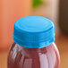 A blue Waterfall tamper-evident cap on a bottle of juice.