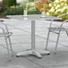 A Lancaster Table & Seating chrome square outdoor table with a white surface.