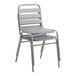 A stack of Lancaster Table & Seating silver metal outdoor side chairs.