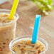Two plastic cups of iced coffee with Choice neon boba straws.