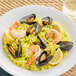 A plate of La Carreta Bomba rice with shrimp, mussels, and lemon wedges.