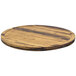 A Front of the House round wooden serving board with black stripes on the surface.