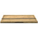 A Front of the House Reversible Crushed Bamboo Serving Board with hand grips on a wooden surface.