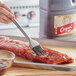 A person using a brush to apply Kraft Original BBQ Sauce to a piece of meat.