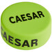 A green silicone lid with black text that reads "Caesar"