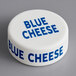 A white circular silicone lid with blue text reading "Blue Cheese"
