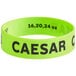 A green silicone wristband that says "Caesar"