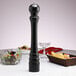 A black Chef Specialties Monarch ebony pepper mill on a table.
