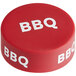 A red "BBQ" silicone lid with white text on a table.