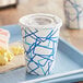A white and blue Choice paper cold cup with a lid on a tray.