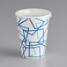 A white paper cold cup with blue geometric lines and a lid with a straw slot.