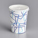A white paper cold cup with a blue design and a lid with a flat straw slot.