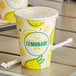 A Carnival King lemonade cup with a flat lid and straw slot with a straw in it.