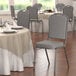 A Lancaster Table & Seating gray fabric banquet chair with silver vein frame.